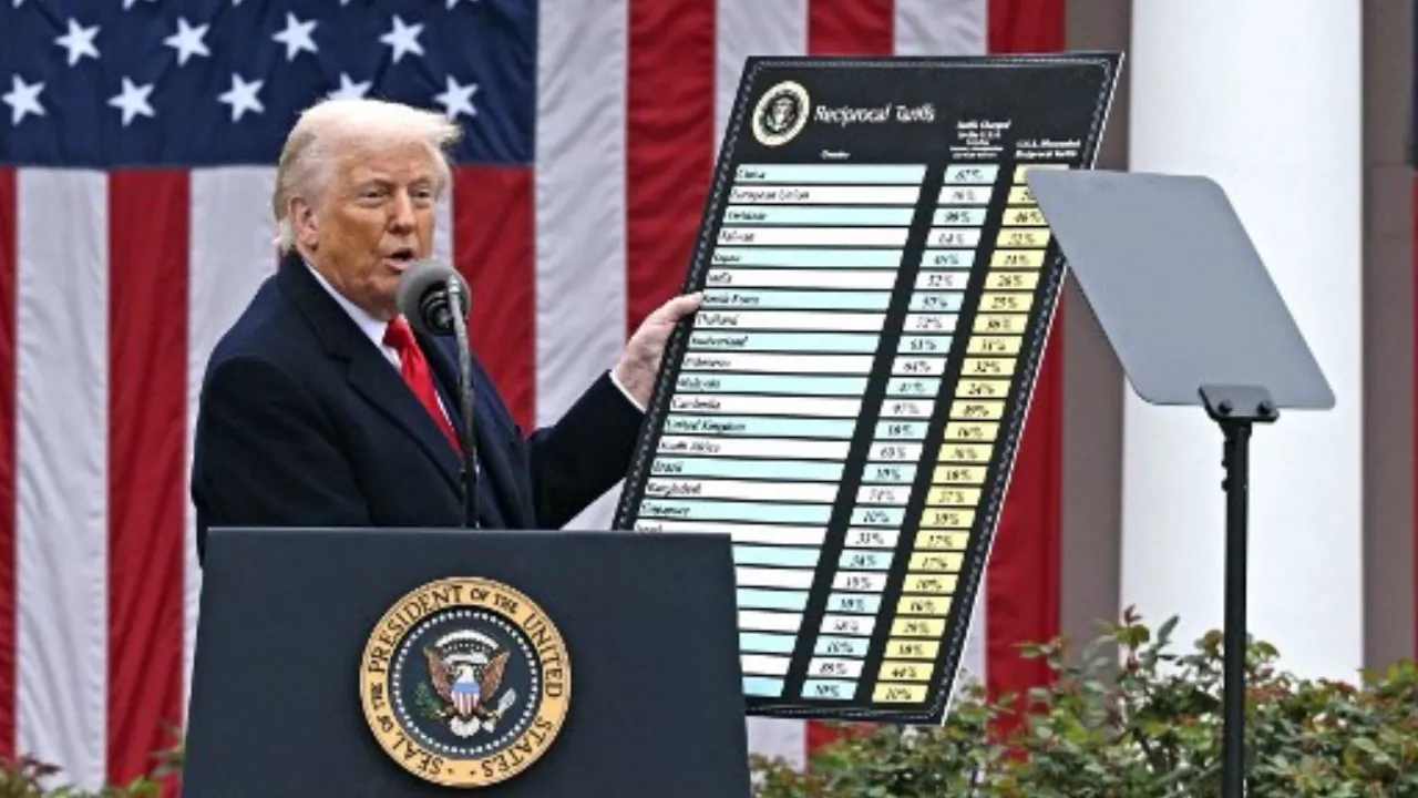  US President Donald Trump delivers remarks on reciprocal tariffs as US Secretary of Commerce Howard Lutnick holds a chart during an event in the Rose Garden entitled "Make America Wealthy Again" at the White House in Washington, DC, on April 2, 2025.  Photograph: (AFP) 