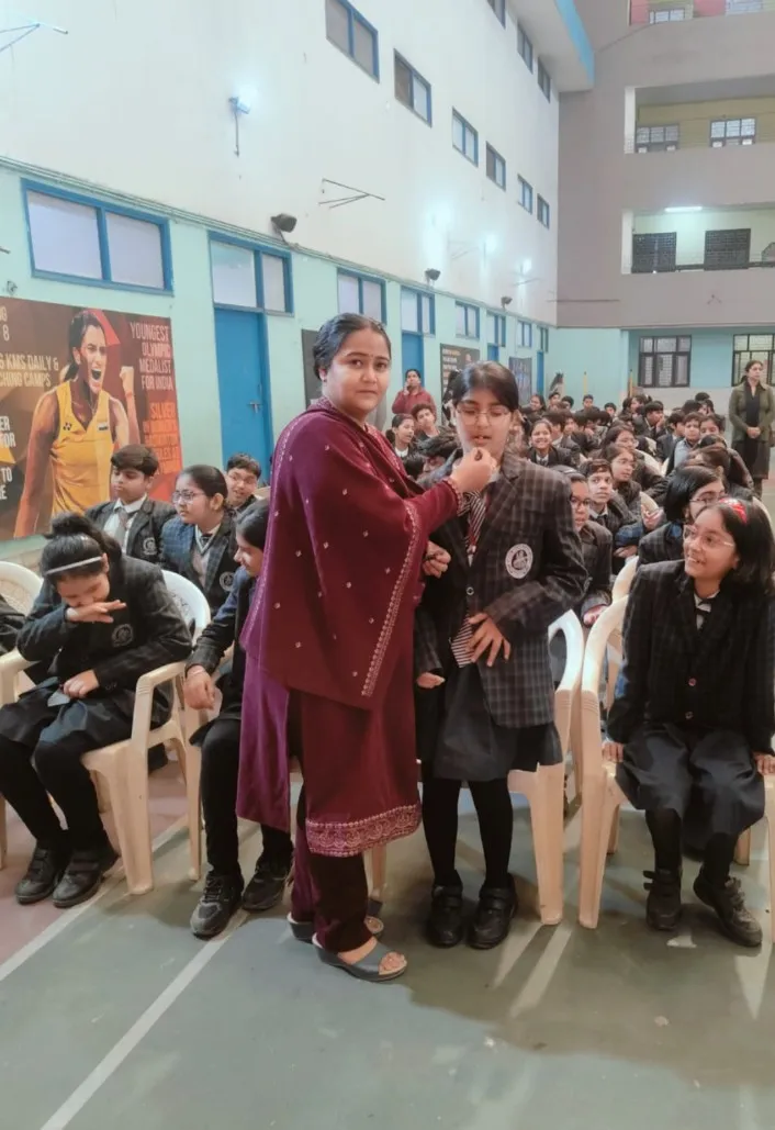 बच्चों को दवा पिलाते शिक्षक