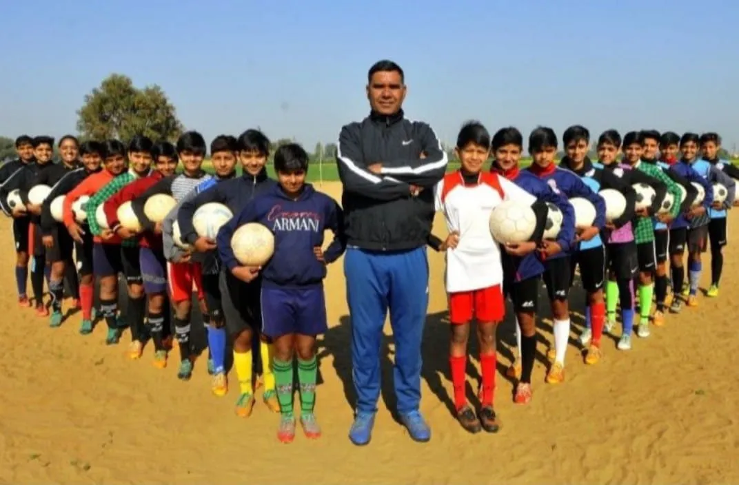 Football coach Vinod Loyal with his trainees at Chuli Bagrian village in Hisar