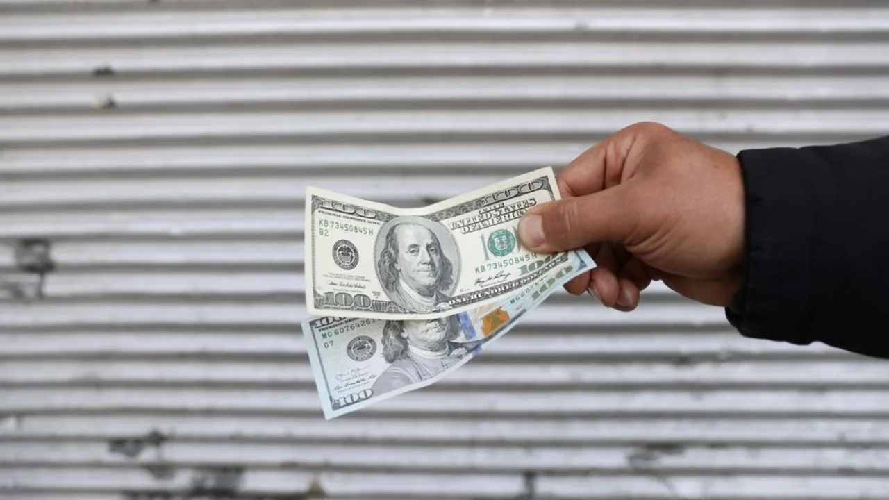  A street-side currency vendor holds US dollars Photograph: (Reuters) 
