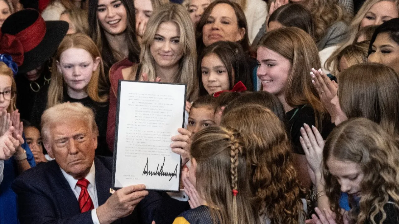  US President Donald Trump holds up the No Men in Women's Sports Executive Order after signing it in the East Room of the White House in Washington, DC, on February 5, 2025. President Trump on Wednesday is signing an executive order to ban transgender girls and women from competing on sports teams that match their gender identity, marking his latest move targeting transgender rights. Photograph: (AFP) 