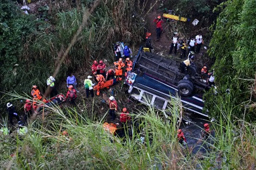  Firefighters and police work at the scene of an accident in which a bus fell down a ravine in Guatemala City on February 10, 2025. Photograph: (AFP) 