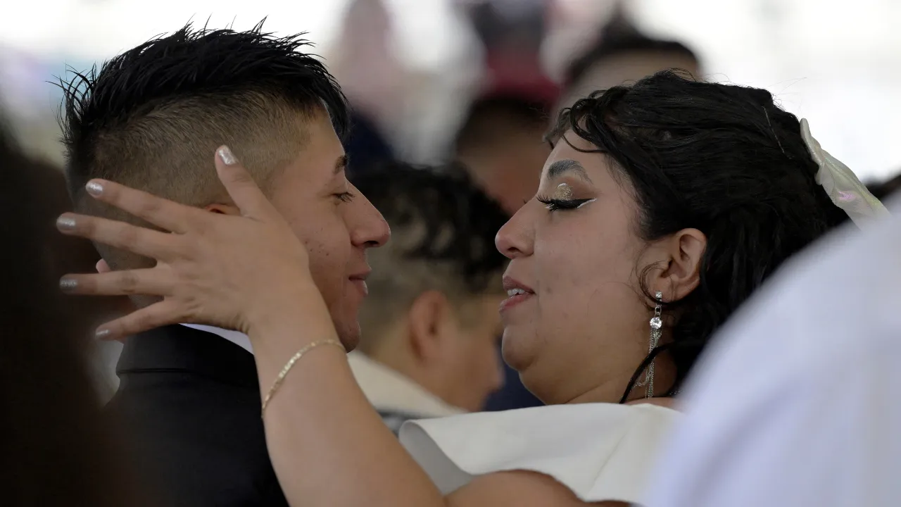  A couple kisses during a collective wedding to celebrate Valentine's Day at the esplanade of the Municipal Palace of Nezahualcoyotl, Mexico Photograph: (AFP) 