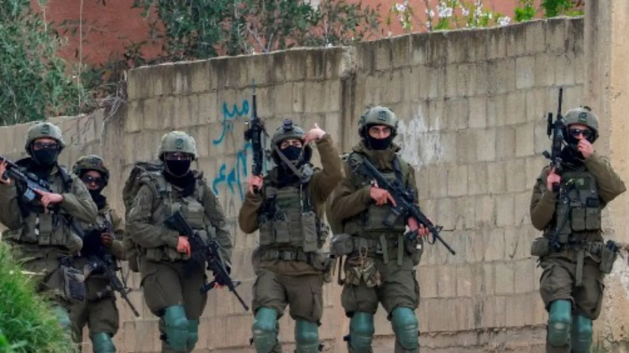  An Israeli soldier gestures during a raid in the occupied-West Bank city of Qabatiya, north of Jenin, on February 23, 2025. Photograph: (AFP) 