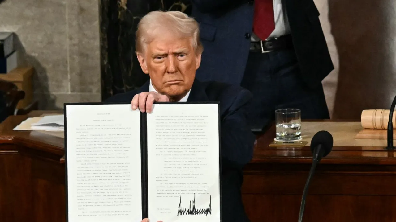  US President Donald Trump holds up an executive order that renames a wildlife sanctuary in honour of the late Jocelyn Nungaray, a 12 year-old girl who was murdered by two undocumented migrants, during an address to a joint session of Congress at the US Capitol in Washington, DC, on March 4, 2025. Photograph: (AFP) 