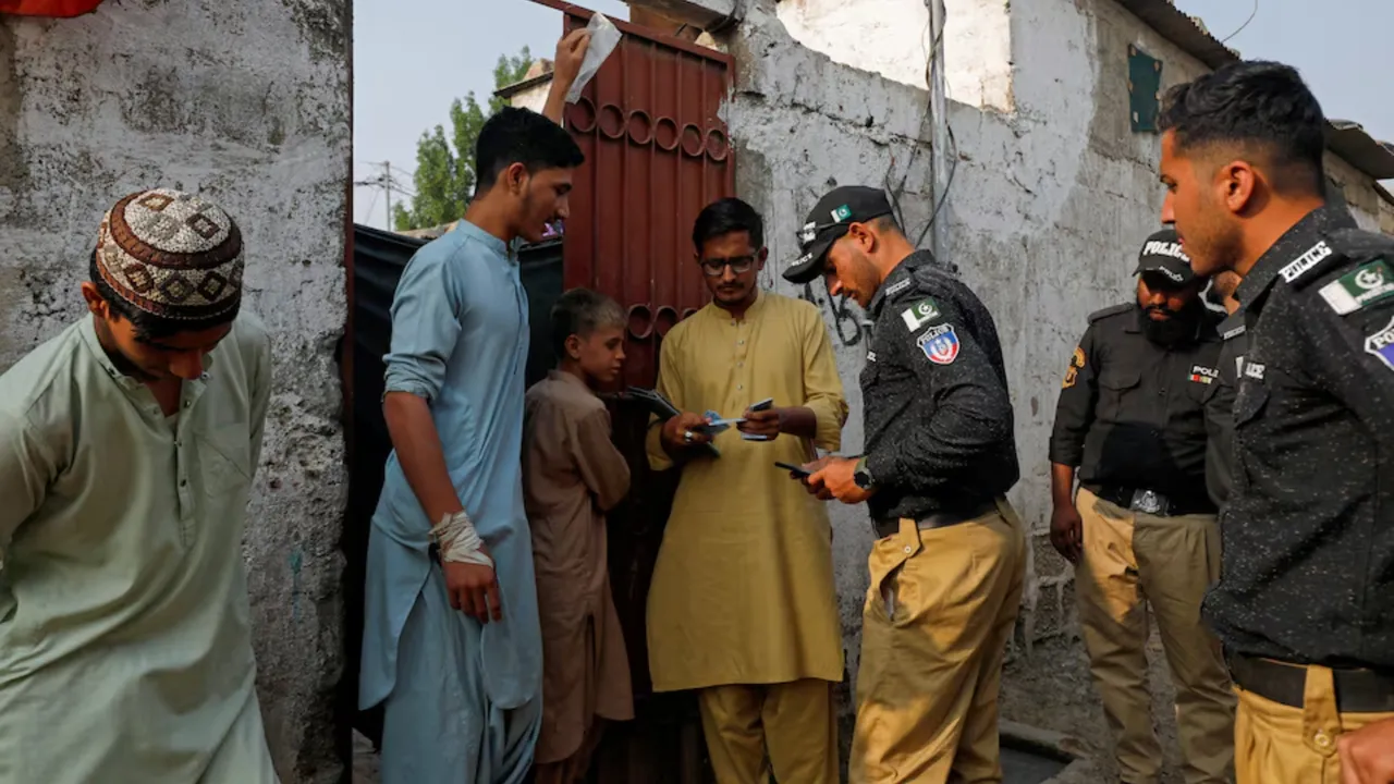  Police officers, along with workers from the National Database and Registration Authority (NADRA), check the identity cards of Afghan citizens during a door-to-door search and verification drive for undocumented Afghan nationals, in an Afghan Camp on the outskirts of Karachi, Pakistan, November 21, 2023. Photograph: (Reuters) 