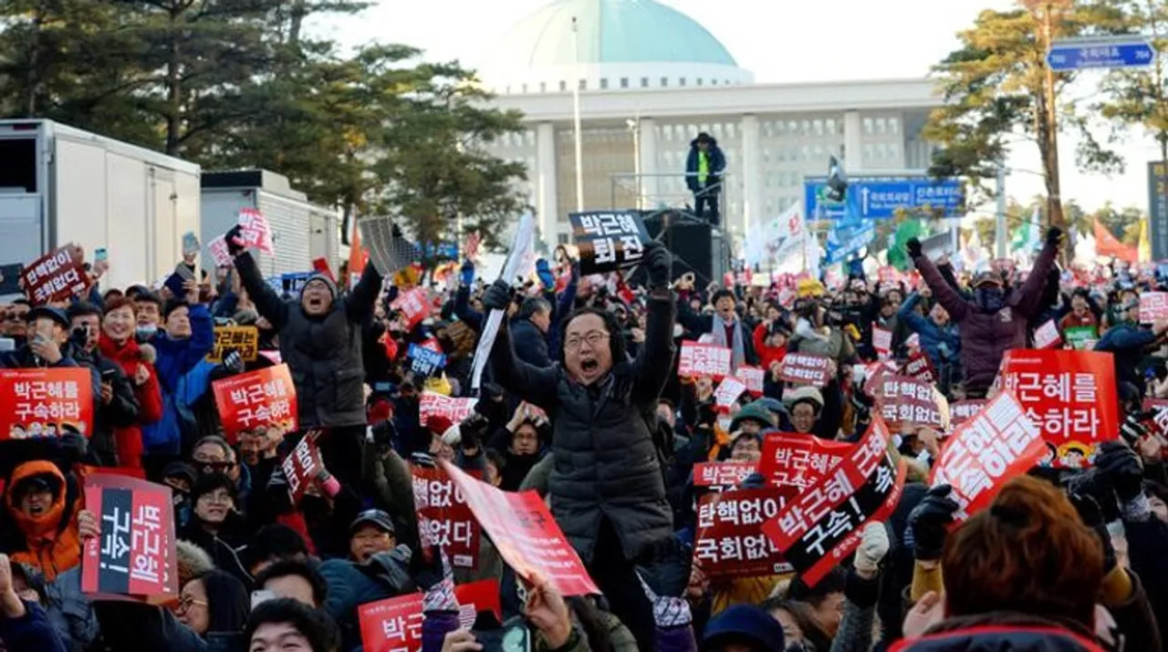  Protesters took selfies before a large banner reading, "Congratulations on the impeachment of Park Geun-hye; Now let's lock her up." Photograph:(Reuters) 