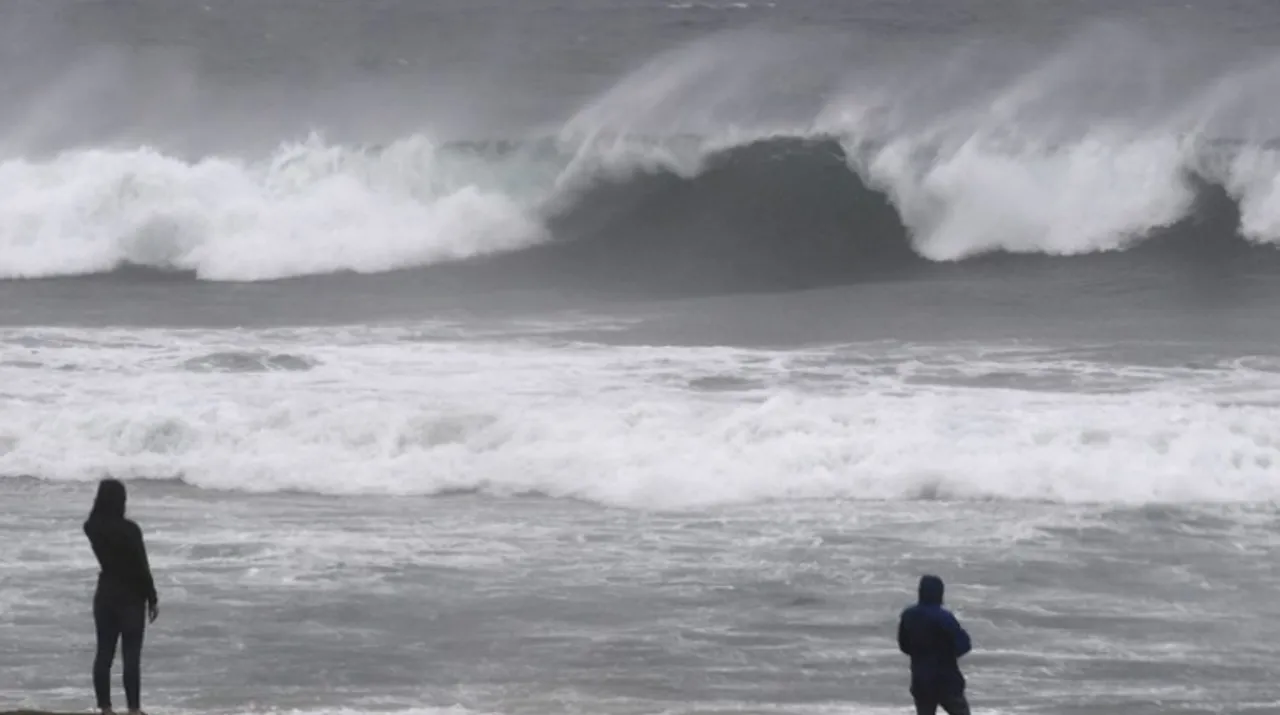  People watch the large waves at El Porto beach as the strongest storm in six years slammed Los Angeles, California, on February 17. Photograph:(AFP) 