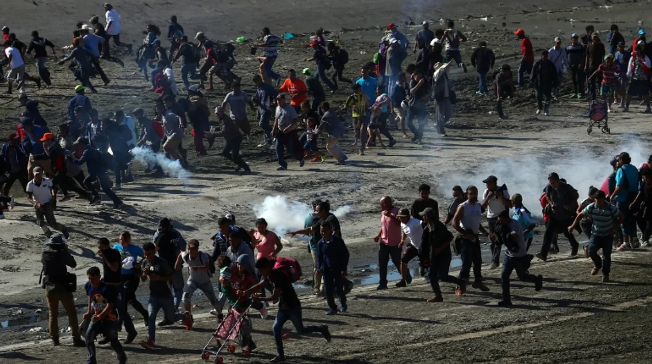  US soldiers and US border patrols fire tear gas towards migrants. Photograph:(Reuters) 