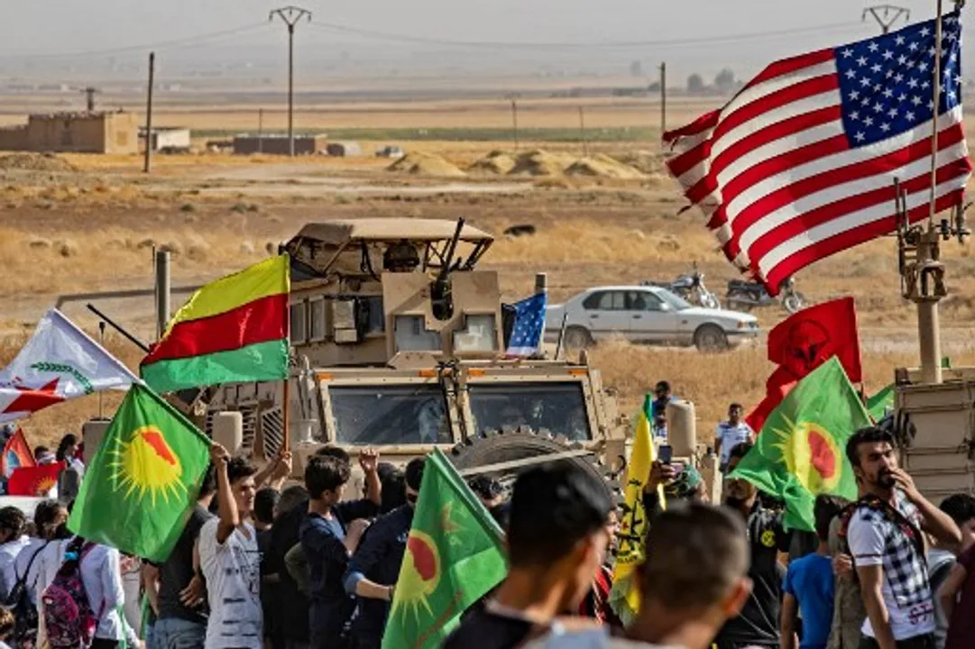  Syrian Kurds gather around US armoured vehicle Photograph:(AFP) 