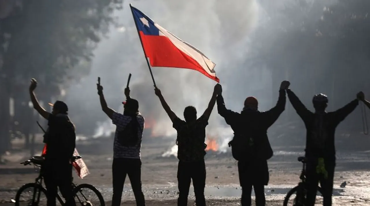  A demonstrator holds a Chilean flag during a protest against Chile's state economic model in Santiago Photograph:(Reuters) 