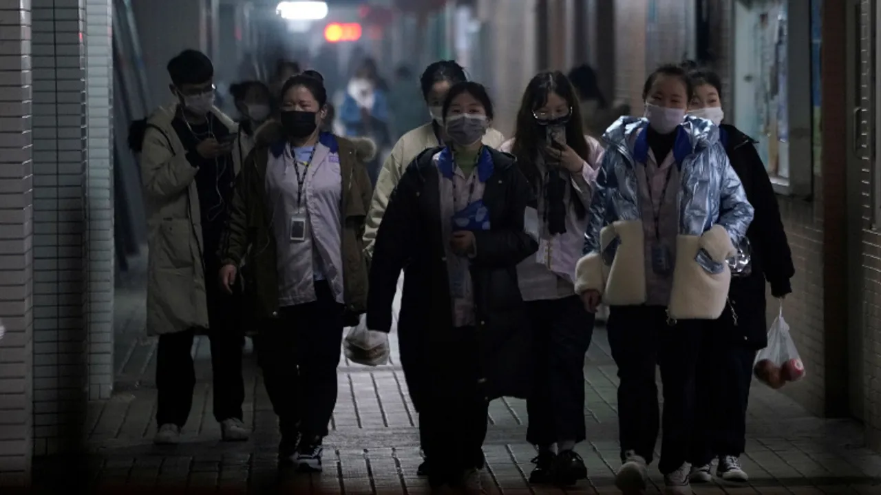  Workers wearing masks walk outside their dormitory, in an electronics manufacturing factory in Shanghai, China Photograph:(Reuters) 