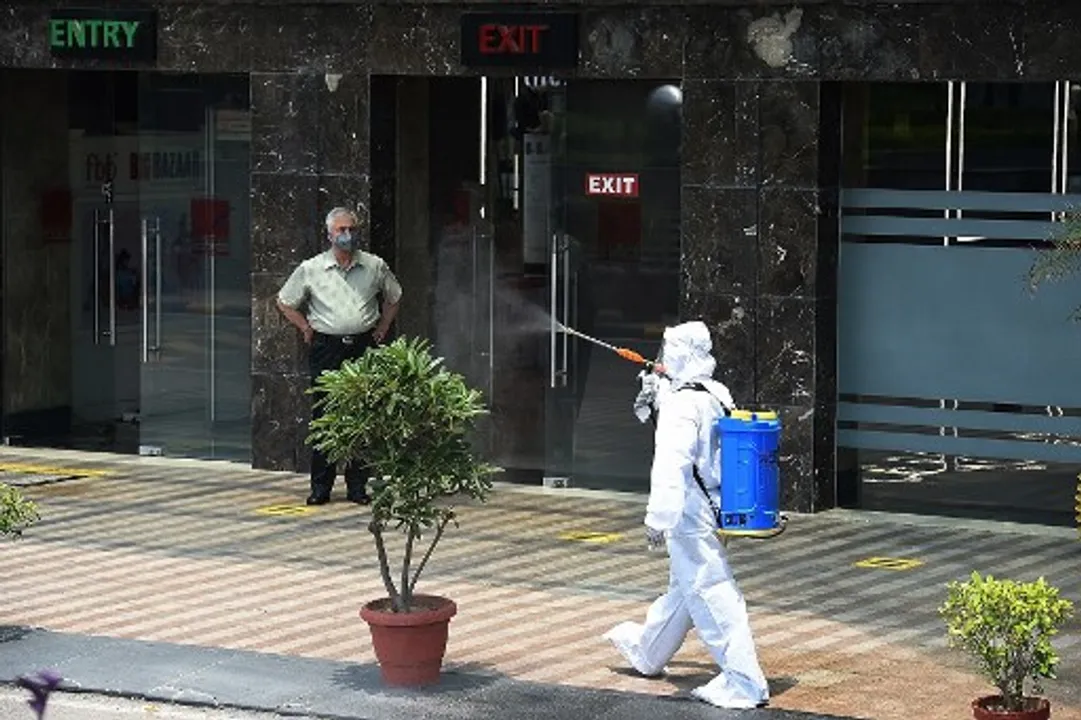  A man wearing Personal Protective Equipment (PPE) sanitizes aÂ mall in New Delhi Photograph:(AFP) 