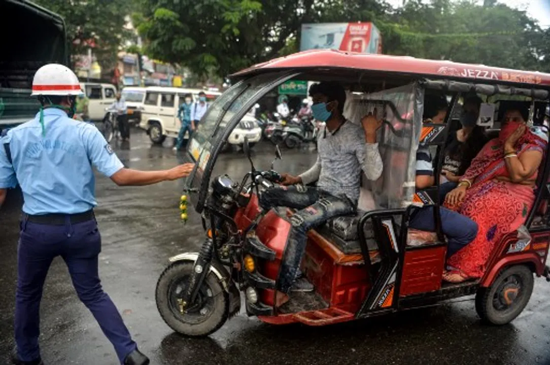  A police personnel stops motorists to warn them of the consequences for not wearing facemasks and not meeting the preventive measures imposed against the COVID-19 in Siliguri  Photograph:(AFP) 