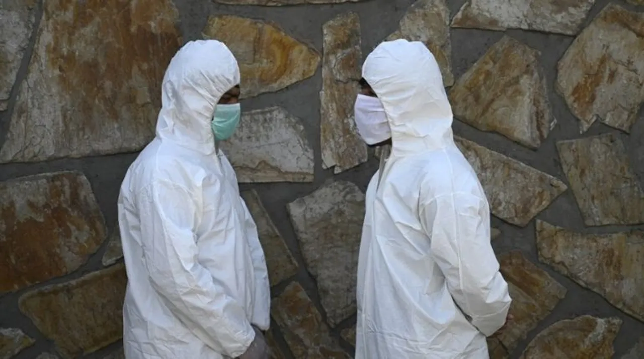  Volunteers wearing protective gear stand before spraying disinfectant on a street as a preventive measure against the spread of COVID-19 coronavirus, in Kabul June 18, 2020 Photograph:(AFP) 