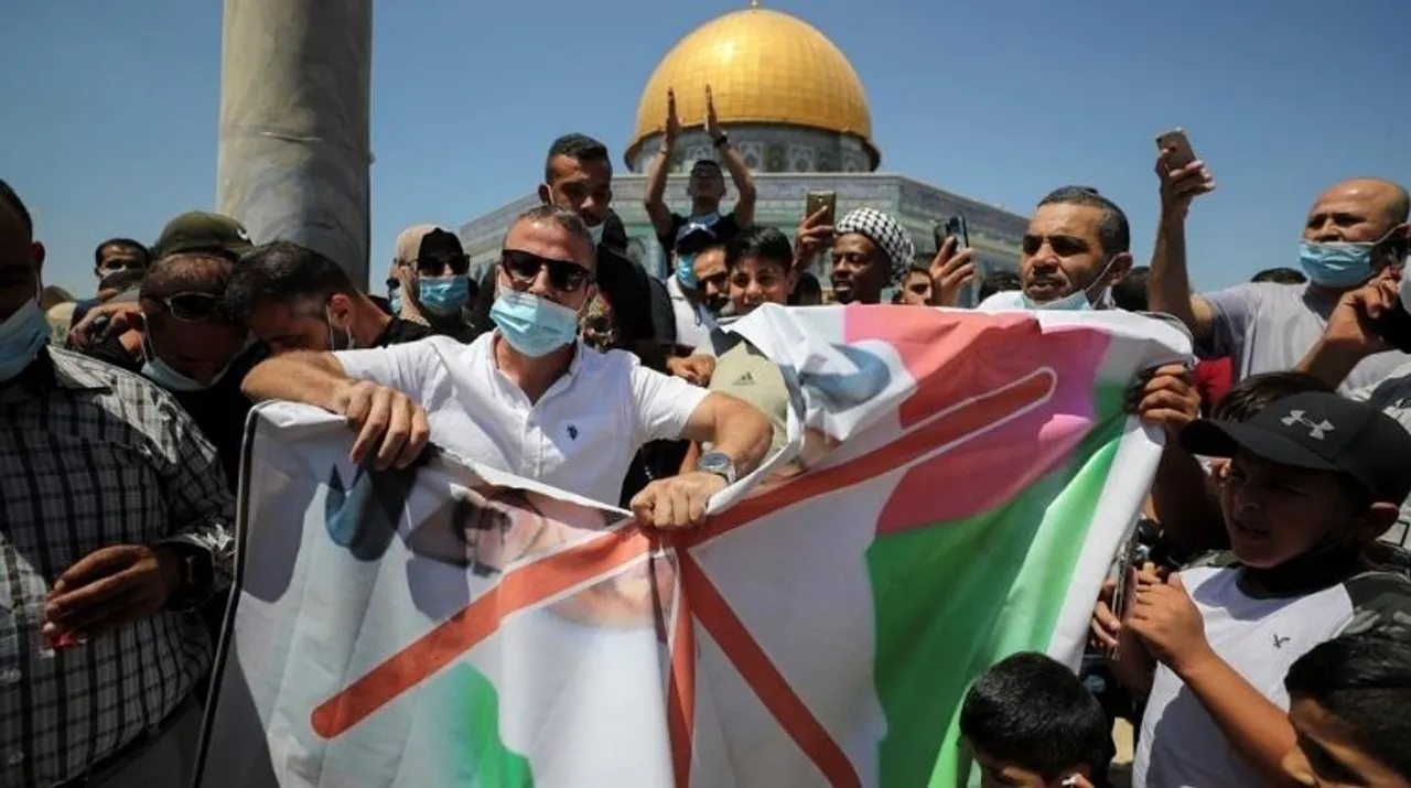  People tear a picture depicting Abu Dhabi Crown Prince Mohammed bin Zayed al-Nahyan during a protest against the United Arab Emirates, in front of the Dome of the Rock, in Jerusalem. Photograph:(Reuters) 