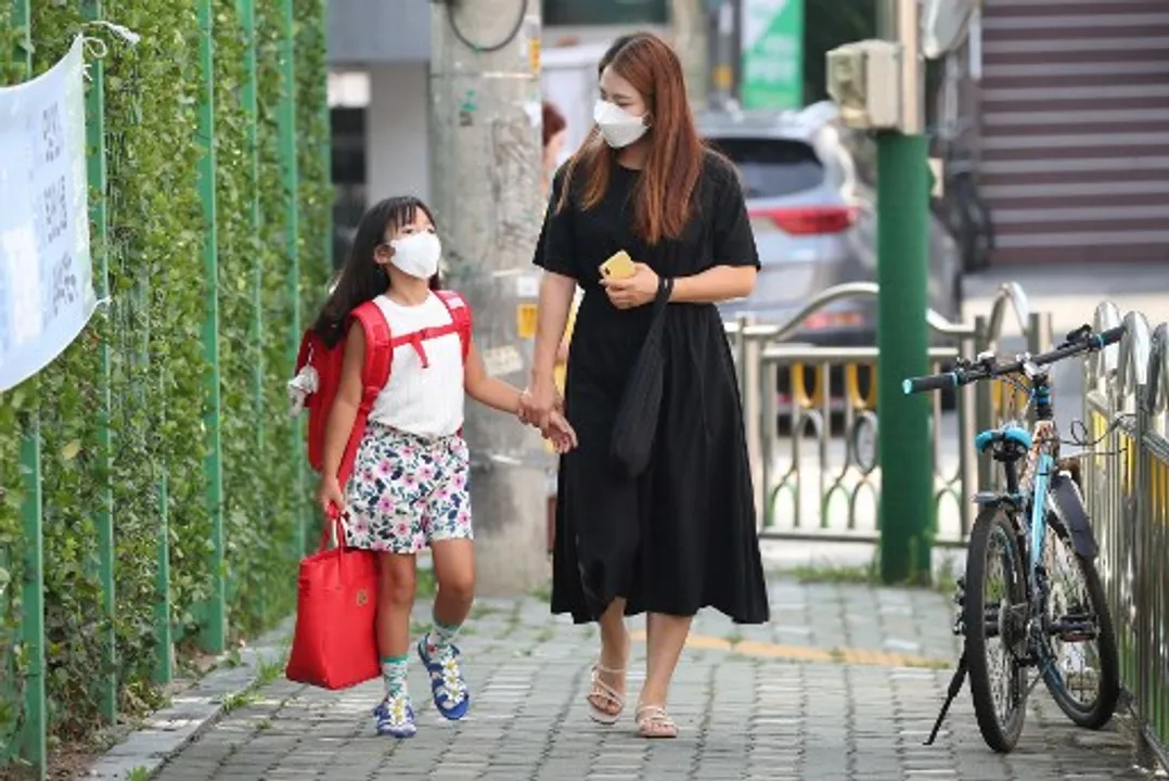  A mother and her daughter walk on their way to an elementary school in Seoul Photograph:(AFP) 