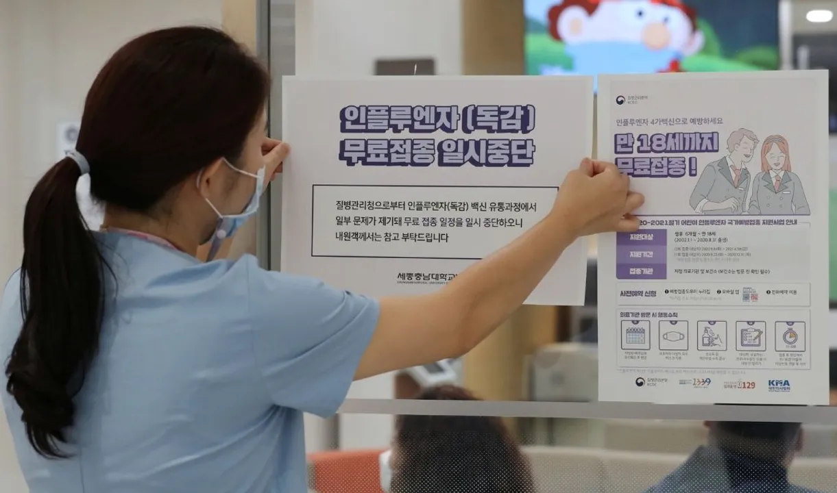  A health worker attaches a notice for suspension of influenza vaccination programs on an entrance of a hospital in Sejong, South Korea, Photograph:(Reuters) 