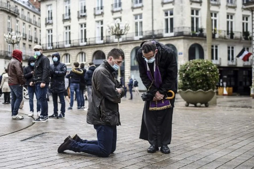  A Catholic priest listens to the confession of a believer during a gathering to call the reopening of places of worship during a national lockdown in France  Photograph:(AFP) 