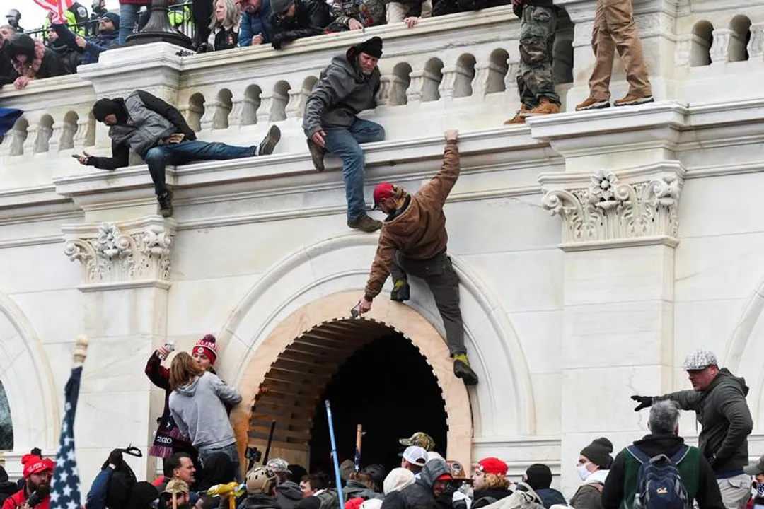  Supporters of President Trump climb a wall at the Capitol Building Photograph:(Reuters) 