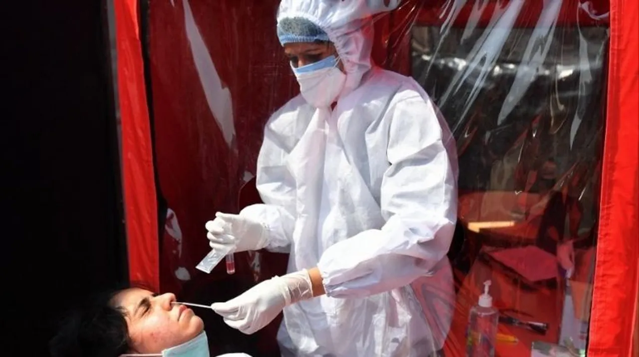  A health worker takes swab sample of a colleague at a portable cabin of a mobile laboratory for conducting RT-PCR Covid-19 coronavirus tests in Mumbai on February 11, 2021. Photograph:(AFP) 