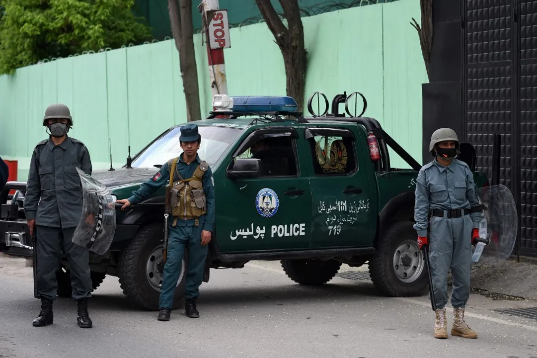  Afghan security personnel stand guard as civil society activists (not pictured) hold banners and shout slogans against the Iranian government during a protest in front of the Iranian embassy in Kabul on May 11, 2020. Photograph:(AFP) 