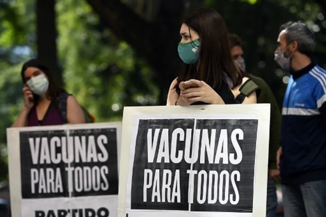  People hold banners reading âVaccines for allâ during a protest of members of leftist parties outside the World Health Organization (WHO) headquarters in Buenos Aires Photograph:(AFP) 