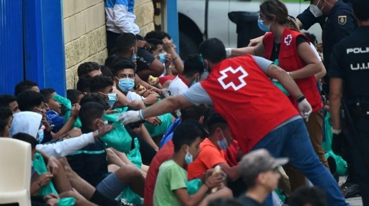  Red Cross members assist migrant minors as they wait to be tested for COVID-19 upon their arrival to the Spanish enclave of Ceuta, on May 19, 2021.  Photograph:(AFP) 