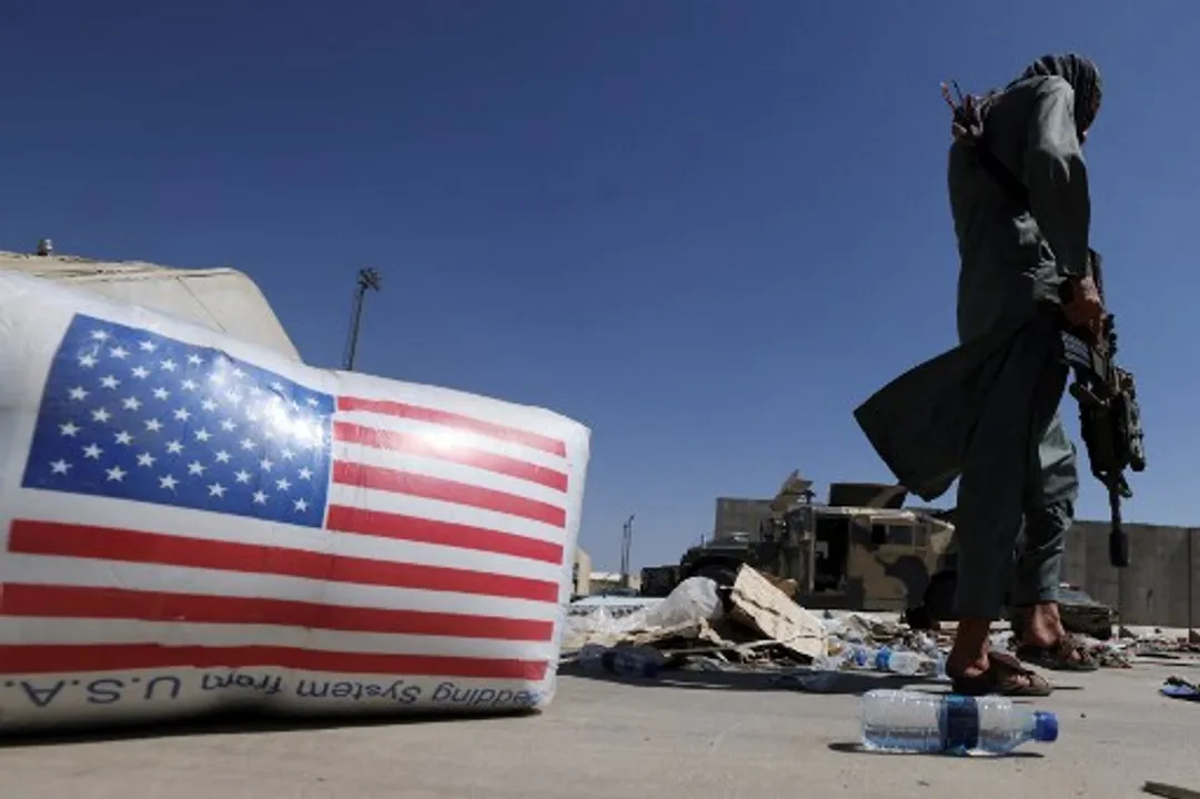  A Taliban fighter walks past a US national flag at the airport in Kabul on September 14, 2021 Photograph:(AFP) 
