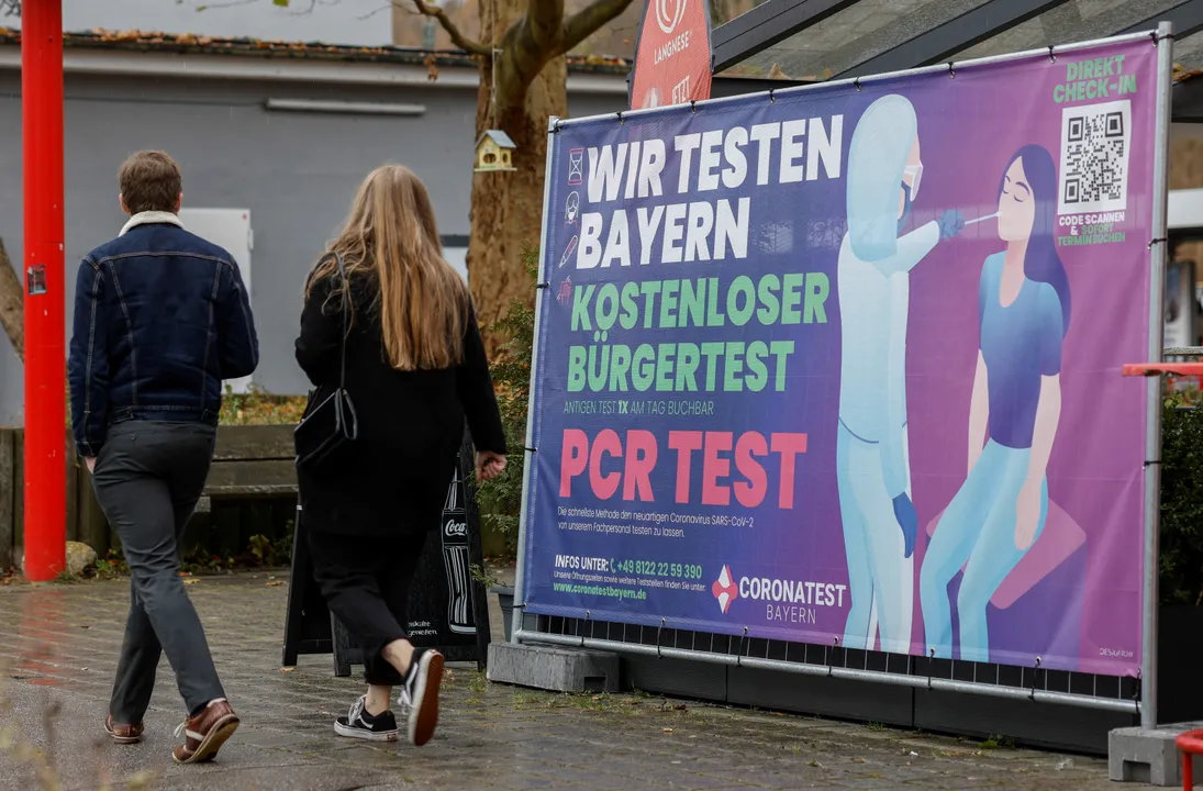  People walk past a COVID-19 test centre amid the pandemic in Furstenfeldbruck, Germany Photograph:(Reuters) 
