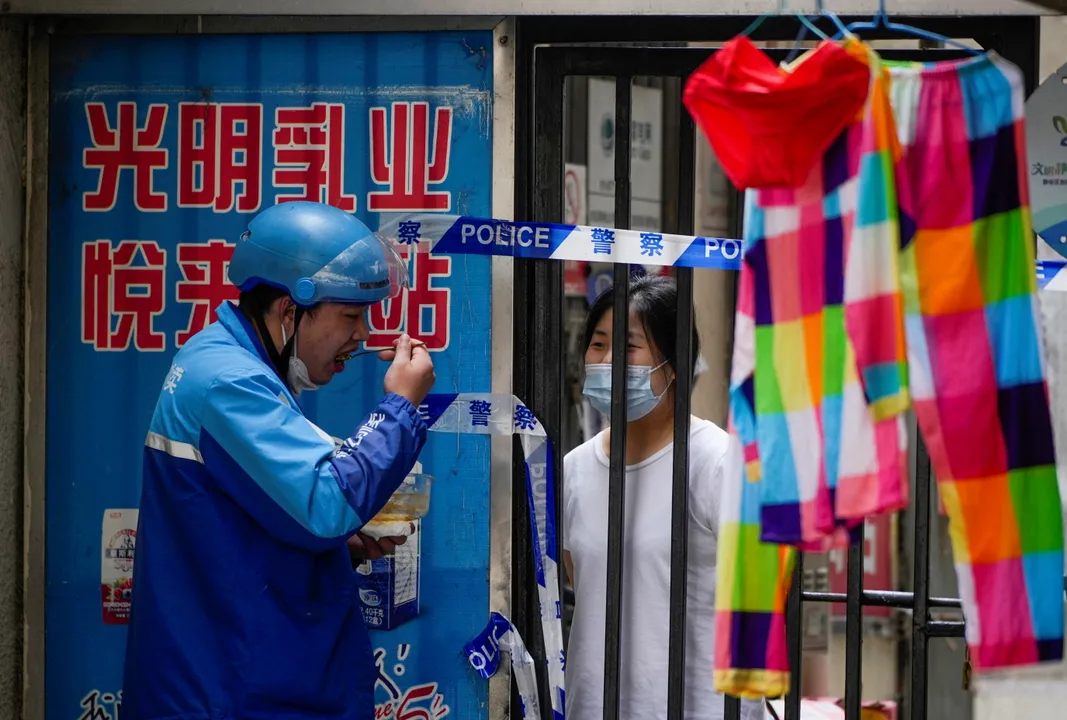  Residents at a closed residential area during lockdownÂ in Shanghai Photograph:(Reuters) 