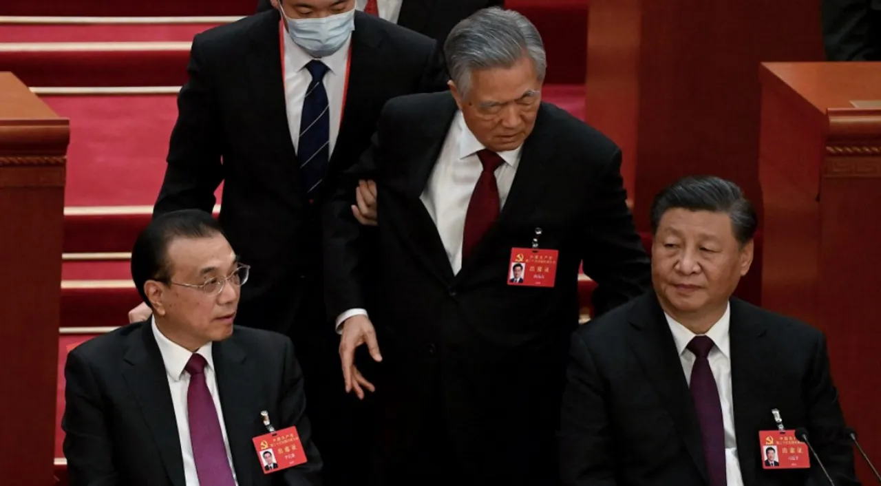  Two men escort Chinese leader Hu Jintao out of the Communist Party's Congress. Photograph:(AFP) 