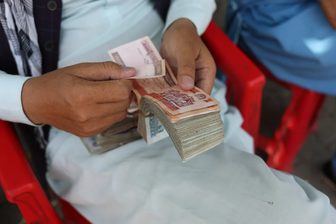  An Afghan man counts his money Photograph:(Reuters) 
