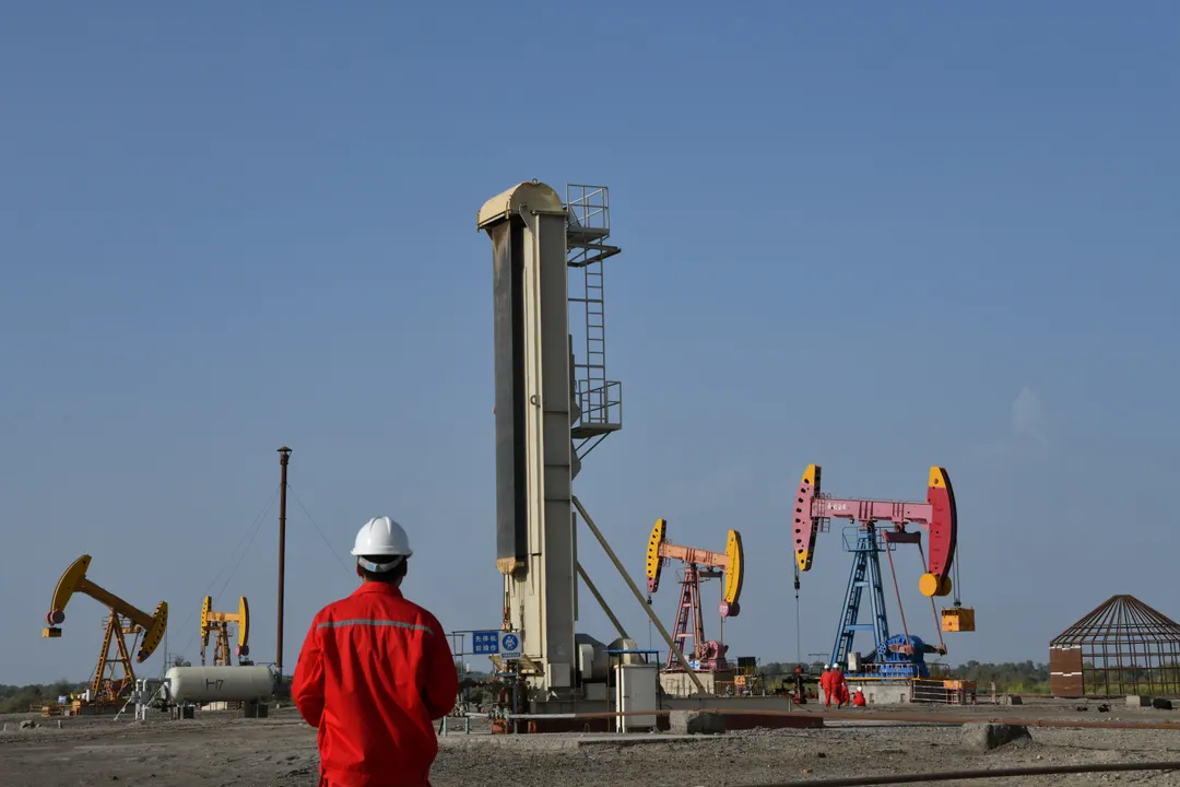  Workers are seen near pumpjacks at a China National Petroleum Corp (CNPC) oil field in Bayingol, Xinjiang Uighur Autonomous Region, China August 7, 2019.  Photograph:(Reuters) 