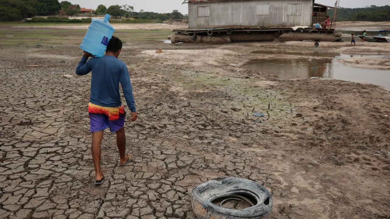  In a parched region near the Igarape do Taruma stream, which feeds into the Rio Negro river, a man holds a bottle of water as the water level at a major river port in the Amazon rain forest of Brazil reaches its lowest point in over a century, spanning at least 121 years. Photograph:(Reuters) 