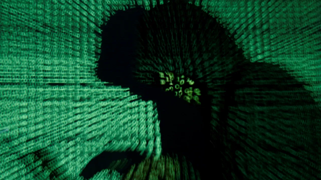  A man holds a laptop computer as cyber code is projected on him in this illustration picture. Photograph:(Reuters) 