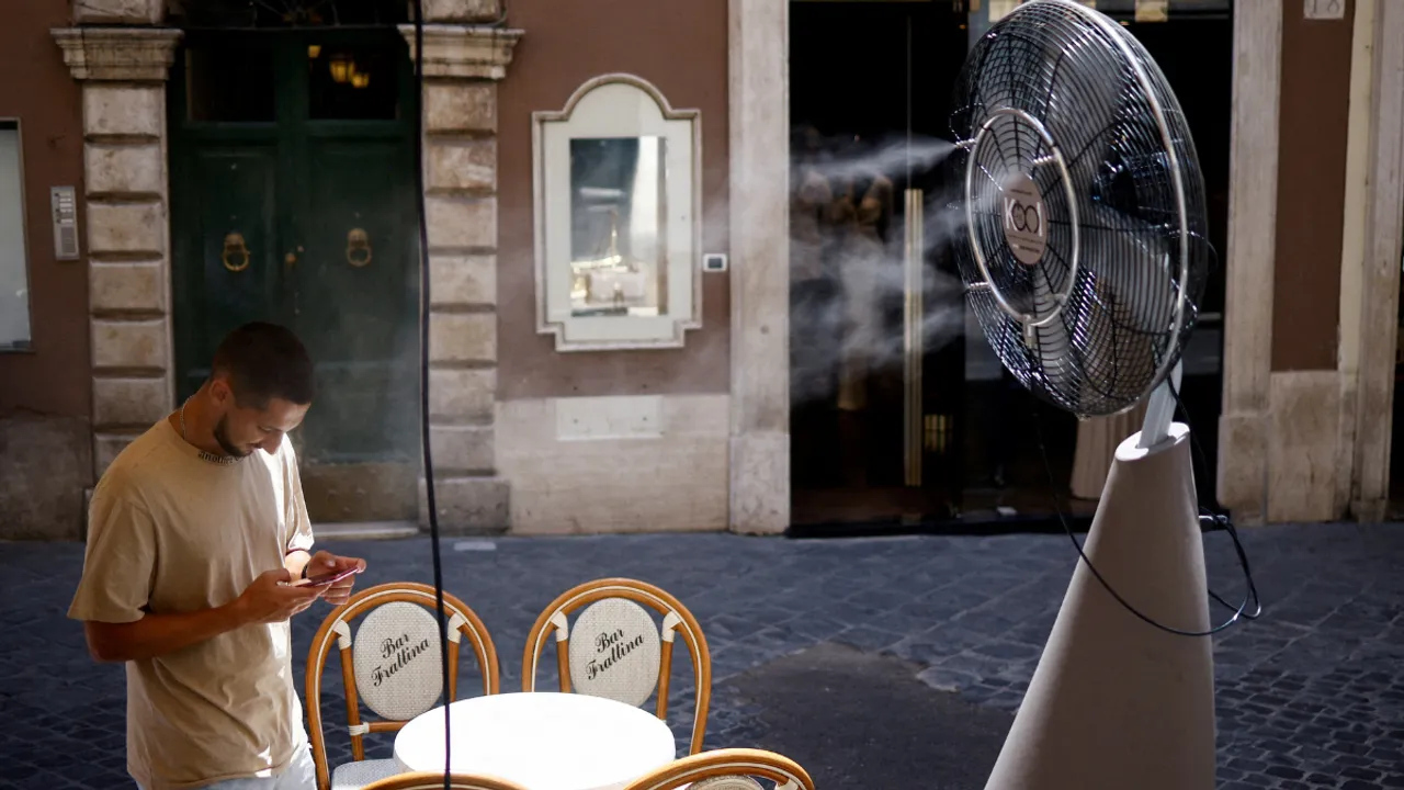  A man beats the rising heat with a cooling fan. Photograph:(Reuters) 
