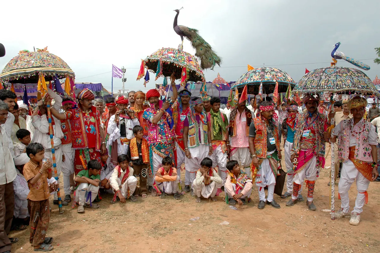Men with embroidered umbrellas seeking partners at the Tarnetar Fair in Surendranagar, Gujarat