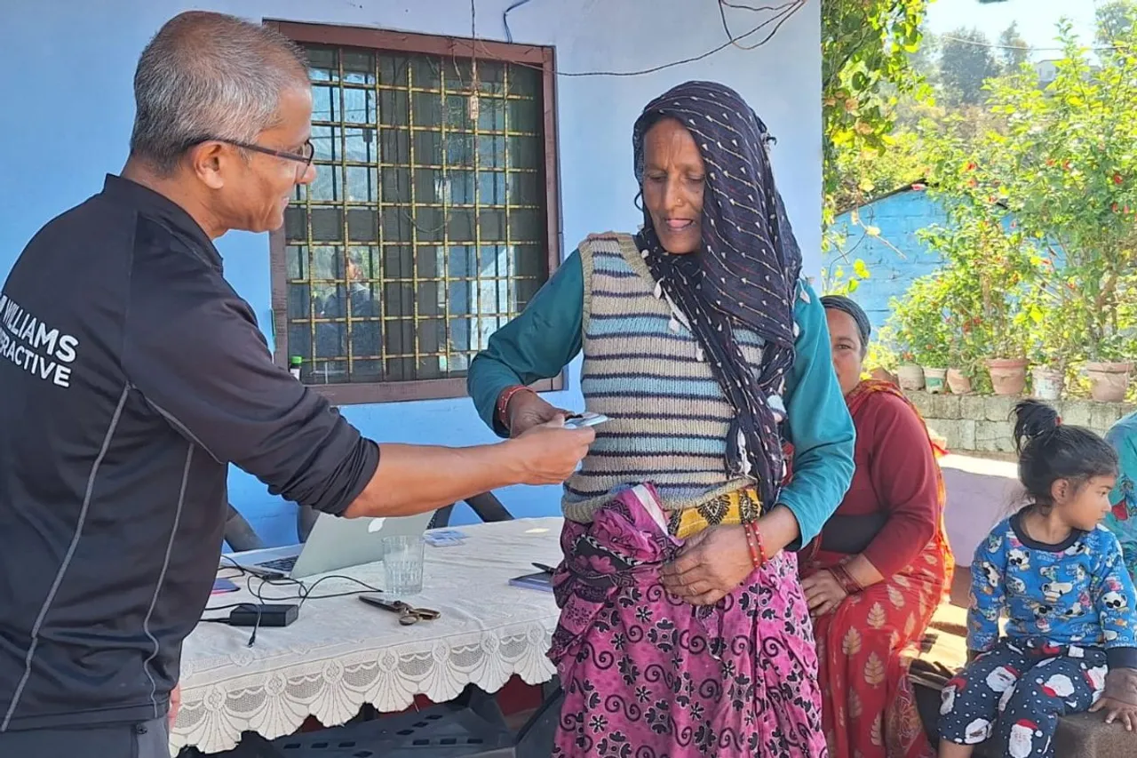 A Tiya Foundation volunteer assists a villager with a telemedicine consultation, ensuring access to medical expertise despite