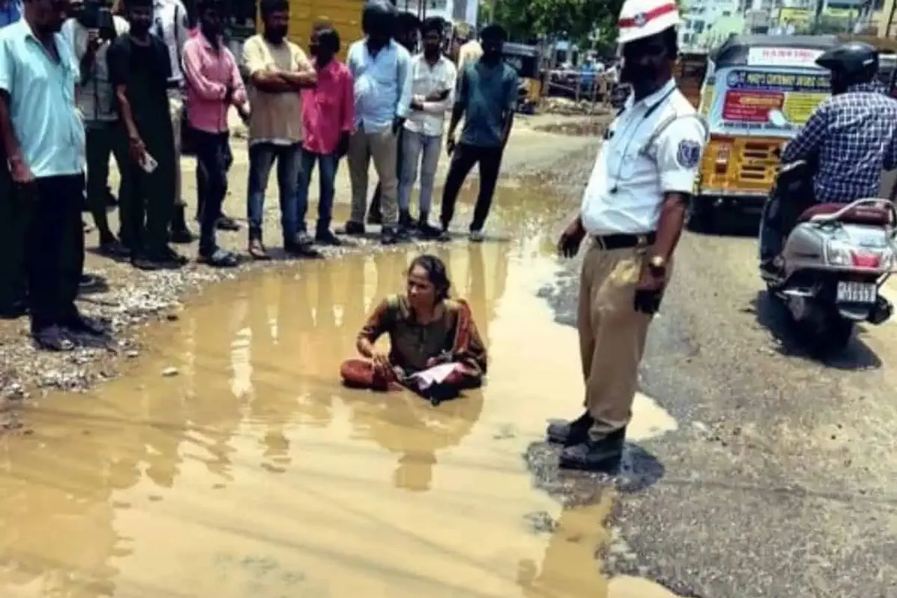 Woman sits in water filled pothole to protest Hyderabad bad roads