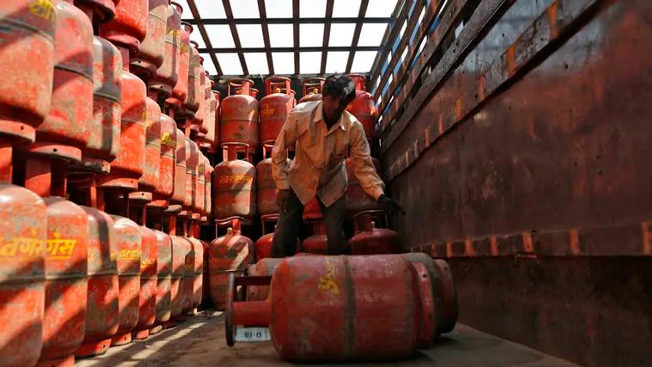 A worker unloads LPG cooking cylinders from a supply truck outside a distribution centre in Ahmedabad