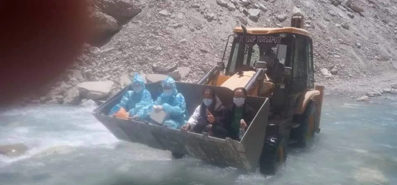These COVID-19 healthcare workers are crossing the river in Ladakh by riding the JCB machine!