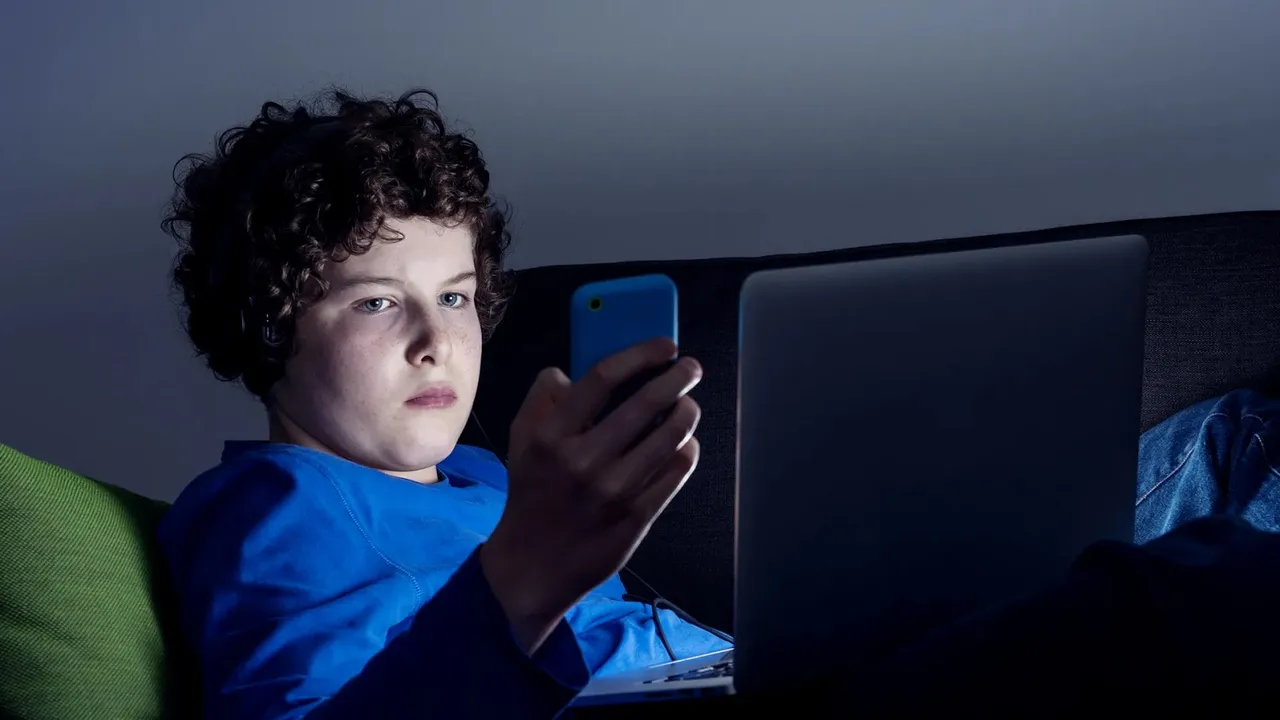 Kid using laptop mobile phone.jpg