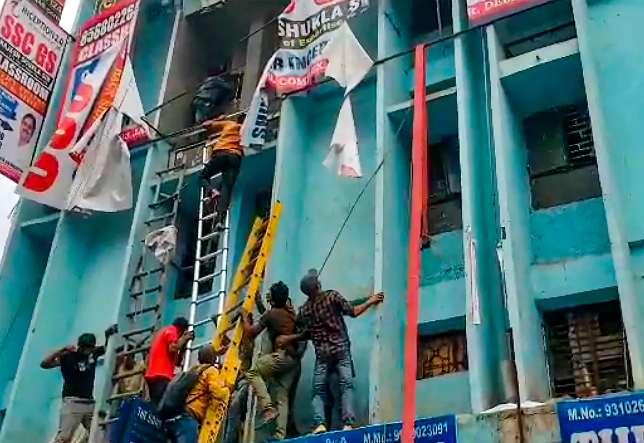 Students being rescued after a fire broke out at a coaching institute, at Mukherjee Nagar area in New Delhi