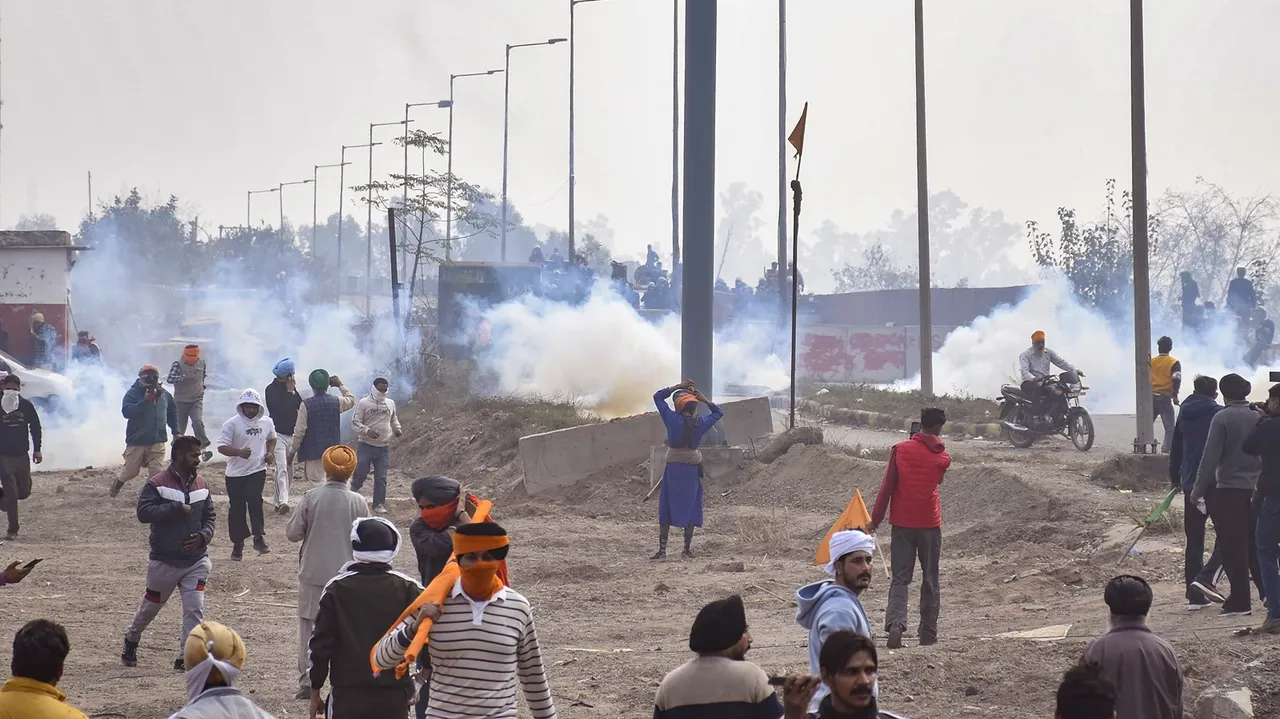 Farmers move away after police fired teargas shell to disperse them during their 'Delhi Chalo' march at Punjab-Haryana Shambhu border