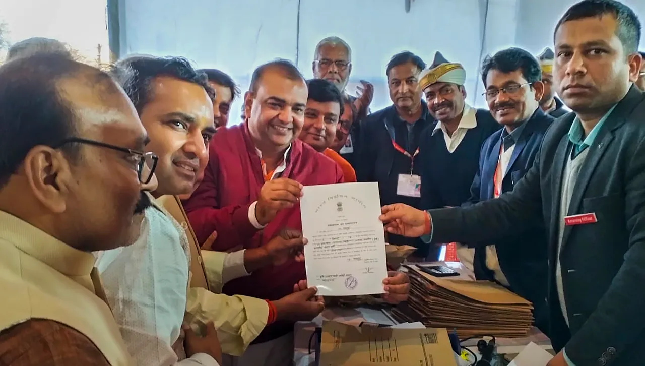 BJP candidate Akash Saxena (in red) receives the 'Certificate of Election' after winning the Rampur Assembly by-elections, in Rampur