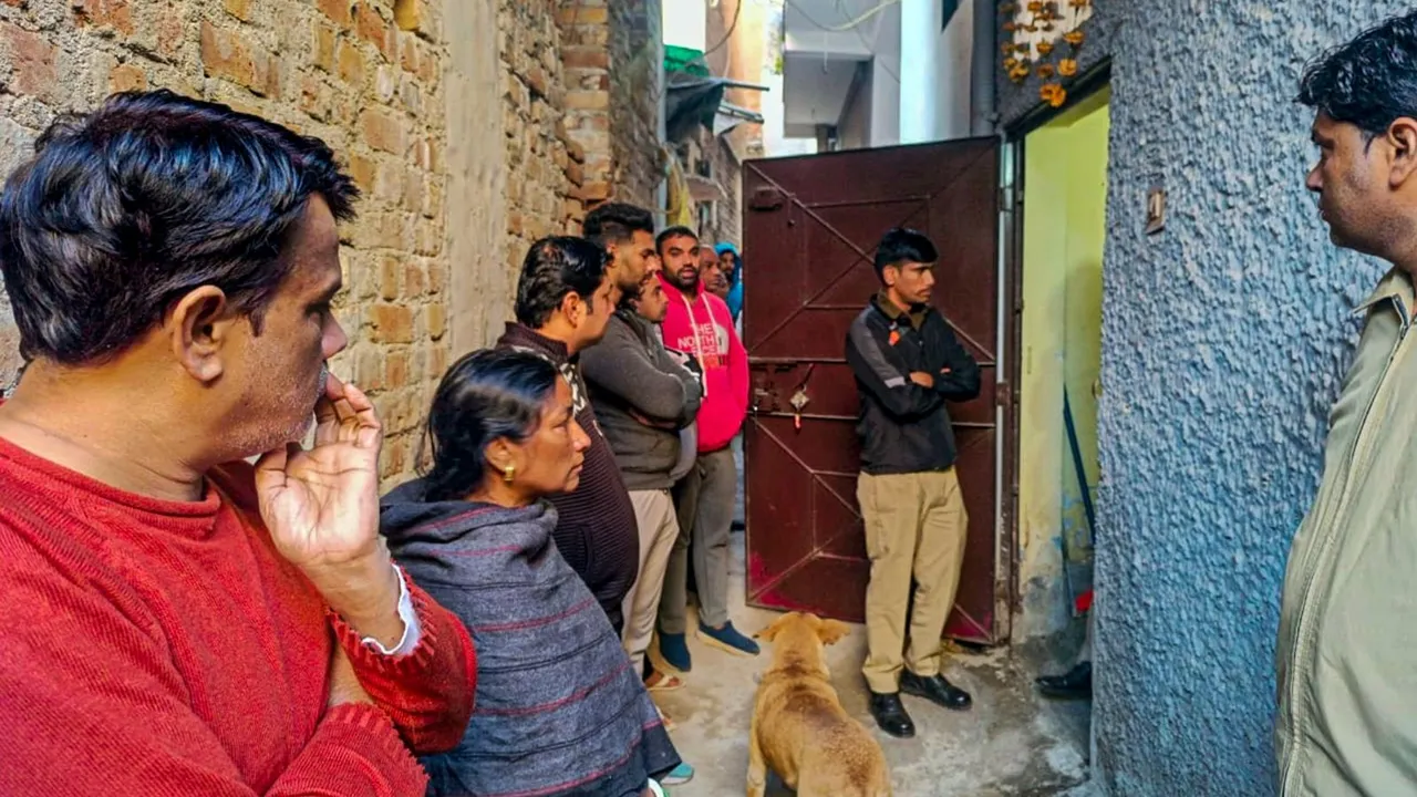 Police personnel and others at a house at Neb Sarai area where a middle-aged couple and their daughter were found dead, in New Delhi, Wednesday, Dec. 4, 2024.