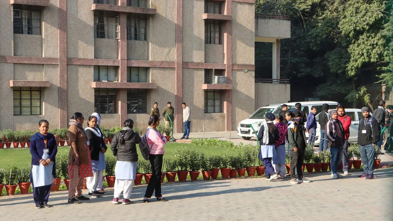 Officials with a sniffer dog inspect the premises of the Cambridge School at Shri Niwas Puri after it received bomb threat over email, in New Delhi, Friday, Dec. 13, 2024.