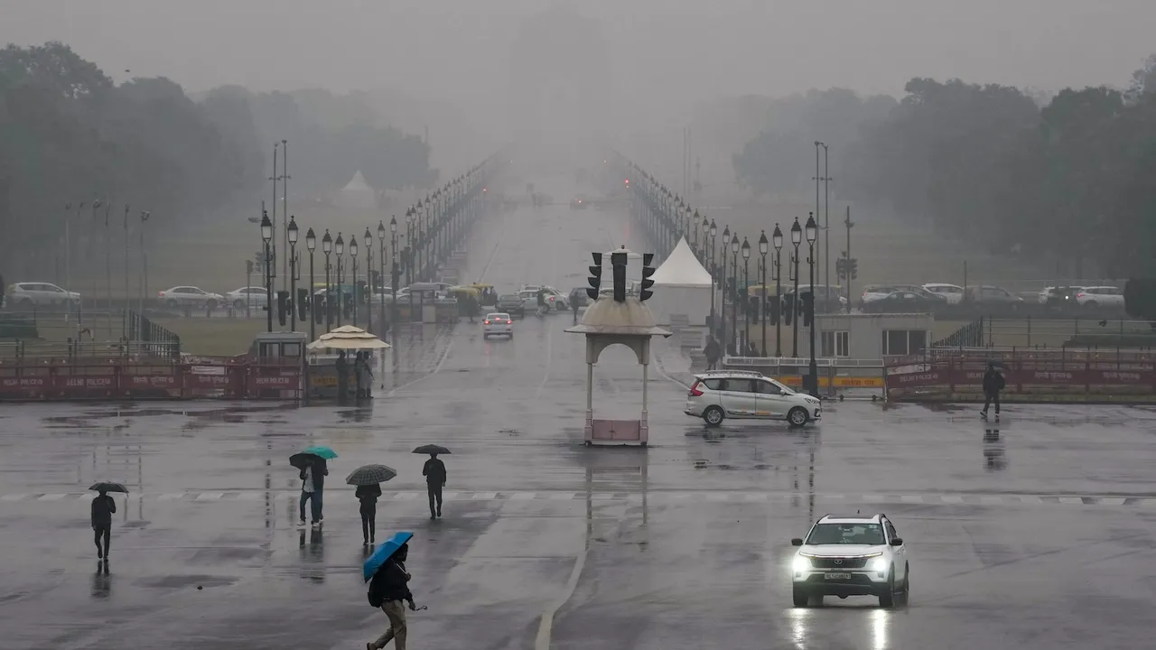 Vehicles move amid rain at Vijay Chowk, in New Delhi, Friday, Dec. 27, 2024.