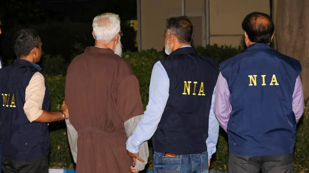 In this image released by NIA on April 10, 2025, Mumbai terror attack accused Tahawwur Hussain Rana with NIA officials upon his arrival at the IGI Airport in New Delhi.
